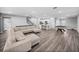 Open-concept living area with a large sectional sofa, hardwood floors, staircase, and connected to a white kitchen at 11232 Bram Bay Ct, San Antonio, FL 33576