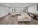 Spacious living room featuring a large sectional sofa, hardwood floors, and large windows for natural light at 11232 Bram Bay Ct, San Antonio, FL 33576