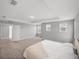 Bright main bedroom with neutral carpet, tray ceiling, and multiple windows for natural light at 11232 Bram Bay Ct, San Antonio, FL 33576