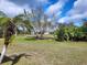 Large backyard featuring beautiful landscaping with native Florida plants and trees at 1318 Misty Greens Dr, Sun City Center, FL 33573