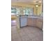 Functional kitchen area with a sink, dishwasher, and view into the adjacent living area at 1318 Misty Greens Dr, Sun City Center, FL 33573