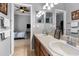 This is a bathroom with double sinks, a sign, and doorways to the bedroom and another room at 13424 Hunters Point St, Spring Hill, FL 34609