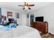 This bedroom features a ceiling fan, posters, a desk and chair, and a dresser with a television on top at 13424 Hunters Point St, Spring Hill, FL 34609