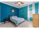 This bedroom features a bright blue accent wall, tile floors, a decorative mirror, and a window with curtains at 13424 Hunters Point St, Spring Hill, FL 34609