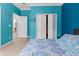 This bedroom features bright blue accent walls, a folding closet door, and a view into another room at 13424 Hunters Point St, Spring Hill, FL 34609