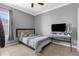 This bedroom features tile floors, gray walls, a flat screen television, and a small window with curtains at 13424 Hunters Point St, Spring Hill, FL 34609