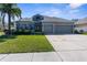 Beautifully maintained home with a two-car garage, lush landscaping, and mature palm at 13424 Hunters Point St, Spring Hill, FL 34609