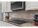 Granite countertops and modern tile backsplash accent the cooktop in this kitchen at 13424 Hunters Point St, Spring Hill, FL 34609