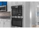 Built-in stainless steel double ovens and backsplash, perfect for cooking at 13424 Hunters Point St, Spring Hill, FL 34609