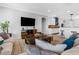 Bright living room flowing into the kitchen, featuring modern furniture, and an entertainment center at 13424 Hunters Point St, Spring Hill, FL 34609