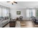 Cozy living room with wood floors, tray ceiling, neutral walls, and abundant natural light through sheer curtains at 13424 Hunters Point St, Spring Hill, FL 34609