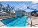 Backyard pool and spa with screen enclosure and patio with an outdoor dining area and umbrella at 13424 Hunters Point St, Spring Hill, FL 34609