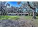 Single-story home with large windows and lush green yard at 13908 Paradise Ln, Dade City, FL 33525