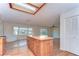 Well-lit kitchen featuring knotty pine cabinets, a center island, and hardwood floors at 13908 Paradise Ln, Dade City, FL 33525