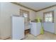 Laundry room with utility sink, washing machine, and exterior door with window at 13908 Paradise Ln, Dade City, FL 33525