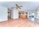 Open-concept living room flowing into the kitchen with hardwood floors and abundant natural light at 13908 Paradise Ln, Dade City, FL 33525