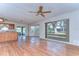 Inviting living area featuring hardwood floors, a ceiling fan, and sliding doors for seamless indoor-outdoor living at 13908 Paradise Ln, Dade City, FL 33525