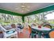 The screened porch is furnished with cushioned wicker furniture and a plastic outdoor table set at 13908 Paradise Ln, Dade City, FL 33525
