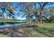 Scenic waterfront view featuring a serene lake surrounded by trees and vegetation at 13908 Paradise Ln, Dade City, FL 33525