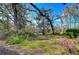 The yard is surrounded by mature trees and flowers at 13908 Paradise Ln, Dade City, FL 33525
