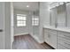 Bright bathroom with double vanity, white cabinets, glass shower and wood-look flooring at 1405 Queensbury Ave, Valrico, FL 33596