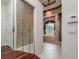 Hallway view to the bathroom featuring tiled floors, shower, soaking tub, and decorative wallpaper at 17104 Tiffany Lake Pl, Lutz, FL 33549