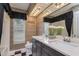 Elegant bathroom with dual sinks, patterned wallpaper, and a decorative mirror at 17104 Tiffany Lake Pl, Lutz, FL 33549