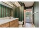 Stylish bathroom featuring colorful striped wallpaper, and access to the pool area at 17104 Tiffany Lake Pl, Lutz, FL 33549