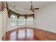 Bright bedroom with hardwood floors, a ceiling fan, and multiple windows dressed with decorative curtains at 17104 Tiffany Lake Pl, Lutz, FL 33549