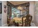 Dining area showcasing pool view, chandelier, and decorative window treatments, creating a luxurious ambiance at 17104 Tiffany Lake Pl, Lutz, FL 33549