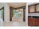 Dining room with large window overlooking the pool, a decorative light fixture, and wooden cabinets at 17104 Tiffany Lake Pl, Lutz, FL 33549