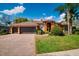 Inviting home featuring a three car garage, brick paver driveway, and well maintained landscaping at 17104 Tiffany Lake Pl, Lutz, FL 33549