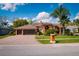 Charming, terracotta-colored home with a brick driveway, mature landscaping, and a spacious three-car garage at 17104 Tiffany Lake Pl, Lutz, FL 33549