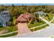 Aerial view of the front exterior featuring a 3 car garage, brick driveway and manicured yard at 17104 Tiffany Lake Pl, Lutz, FL 33549