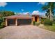 Spacious three-car garage with dark doors and brick driveway offers ample parking and curb appeal at 17104 Tiffany Lake Pl, Lutz, FL 33549