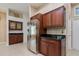 Kitchen featuring stainless steel refrigerator, dark countertops, and wooden cabinets for ample storage at 17104 Tiffany Lake Pl, Lutz, FL 33549