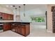 Kitchen view showcasing dark countertops, stainless steel appliances, and decorative hanging lights at 17104 Tiffany Lake Pl, Lutz, FL 33549