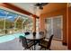 Covered patio featuring an outdoor dining set overlooks a sparkling swimming pool and backyard at 17104 Tiffany Lake Pl, Lutz, FL 33549