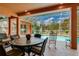 Screened-in patio featuring an outdoor dining set overlooks a sparkling swimming pool and manicured backyard at 17104 Tiffany Lake Pl, Lutz, FL 33549