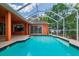 Backyard pool featuring cool decking, screened enclosure, and a home with an orange exterior at 17104 Tiffany Lake Pl, Lutz, FL 33549