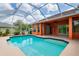 Screened in backyard pool with blue water and orange home exterior at 17104 Tiffany Lake Pl, Lutz, FL 33549