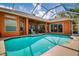 Sparkling screened-in pool boasts serene views of the green lawn, mature trees, and blue skies at 17104 Tiffany Lake Pl, Lutz, FL 33549