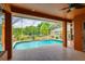 View of the screened in pool with ample patio space and views of the surrounding trees at 17104 Tiffany Lake Pl, Lutz, FL 33549