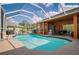 Sparkling screened-in pool boasts serene views of the green lawn, mature trees, and blue skies at 17104 Tiffany Lake Pl, Lutz, FL 33549