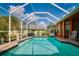 Sparkling screened-in pool boasts serene views of the green lawn, mature trees, and blue skies at 17104 Tiffany Lake Pl, Lutz, FL 33549