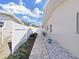 Paver walkway along the side of the house, lined with greenery and white stones at 2056 Imperial Way, Clearwater, FL 33764