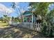 Charming blue home featuring a red front door, surrounded by a white picket fence and lush greenery at 2419 Mallory Ave, Tampa, FL 33605