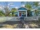 Charming blue cottage-style home featuring a white picket fence, red front door, and welcoming porch at 2419 Mallory Ave, Tampa, FL 33605