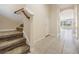 Open foyer with tile flooring and a carpeted staircase leading to the upper level at 26932 Juniper Bay Dr, Wesley Chapel, FL 33544