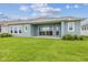 Spacious backyard featuring a well-maintained lawn, covered patio, and blue siding at 31430 Hayman Loop, Wesley Chapel, FL 33545